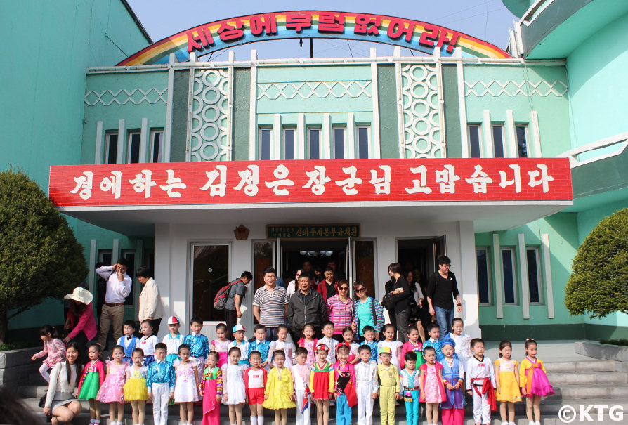Les touristes chinois posent avec des enfants à l'école maternelle de Ponbu à Sinuiju, province de Pyongan du Nord, Corée du Nord (RPDC). Visite organisée par KTG Tours