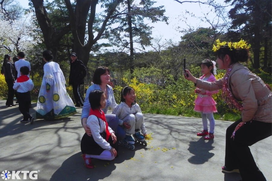 North Korean ladies laughing and celebrating Labour Day i.e. May Day with KTG travellers in Moran Park. Moranbong park is located in the centre of Pyongyang capital of North Korea, the DPRK. Picture taken by KTG Tours experts in DPRK North Korea tours.