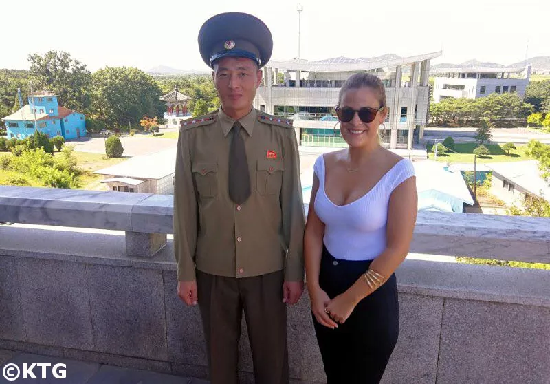 KTG traveller and KPA officer pose for a picture at the building facing the military demarcation line and freedom house in South Korea. North Korean military officers are very friendly with travellers at the DMZ