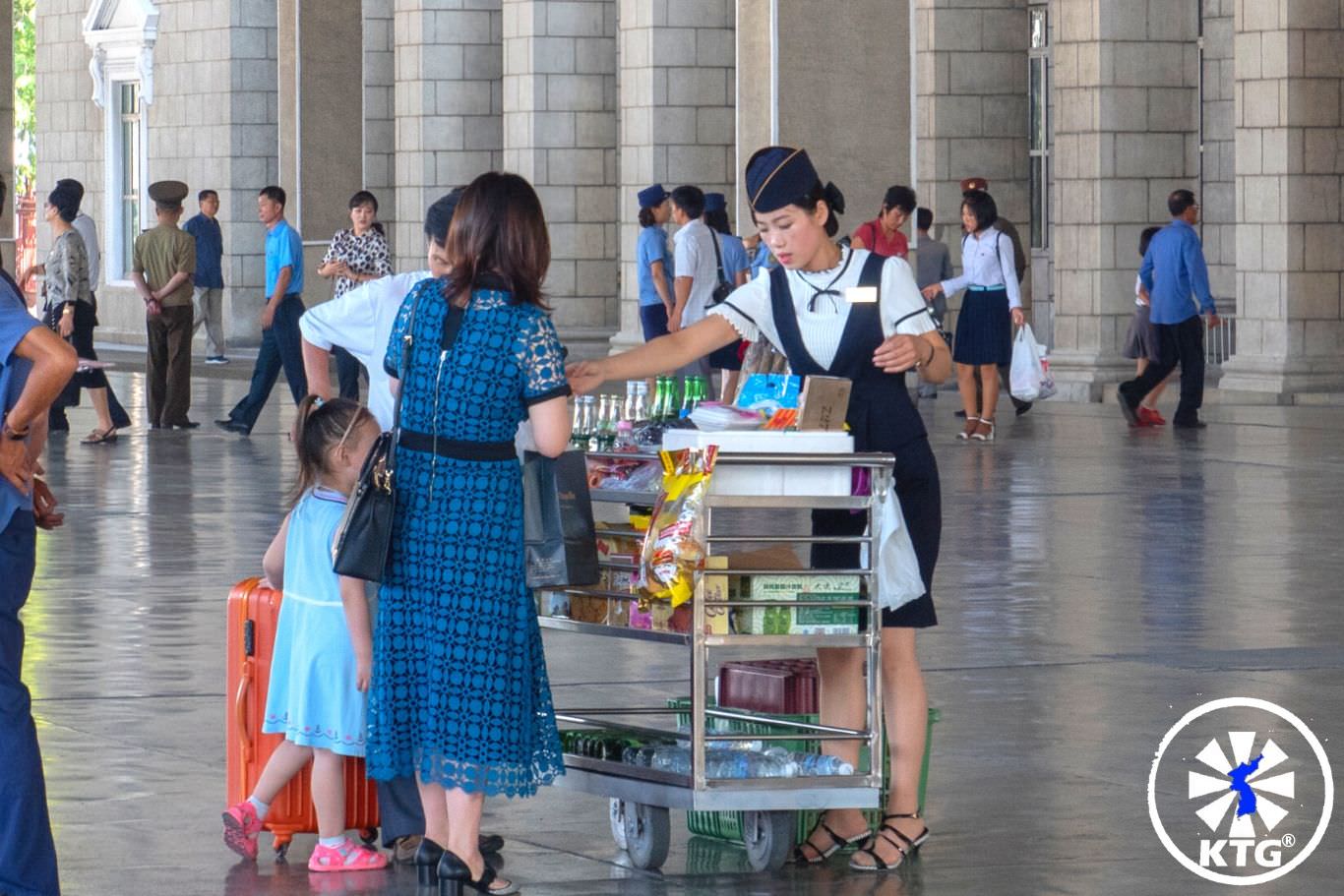 Lady selling snacks at the Pyongyang train station, North Korea (DPRK) before we take the train to China. Picture taken by KTG®